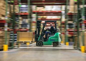 A forklift moving through warehouse racking