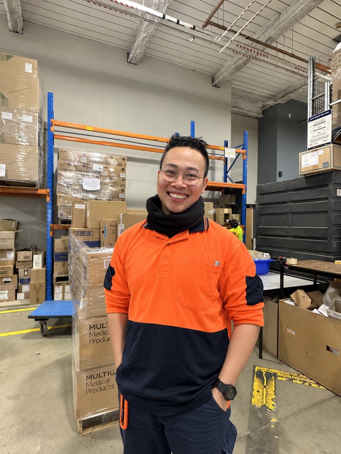 A smiling Chandler worker in hi-vis on a warehouse floor