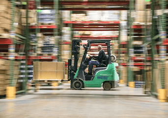 A forklift moving through warehouse racking