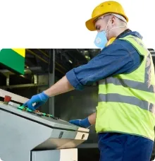 worker operating a machine in high visibility clothing