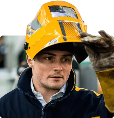 male welder wearing a welding mask smiling at the camera