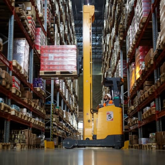 High reach forklift truck in a warehouse lifting boxes