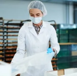 Food production worker, packing baked goods into packaging