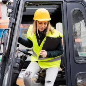 female forklift driver exiting a gas-powered forklift