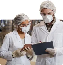 Senior manager talking to a colleague standing next to a manufacturing line