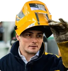 male welder wearing a welding mask smiling at the camera\n